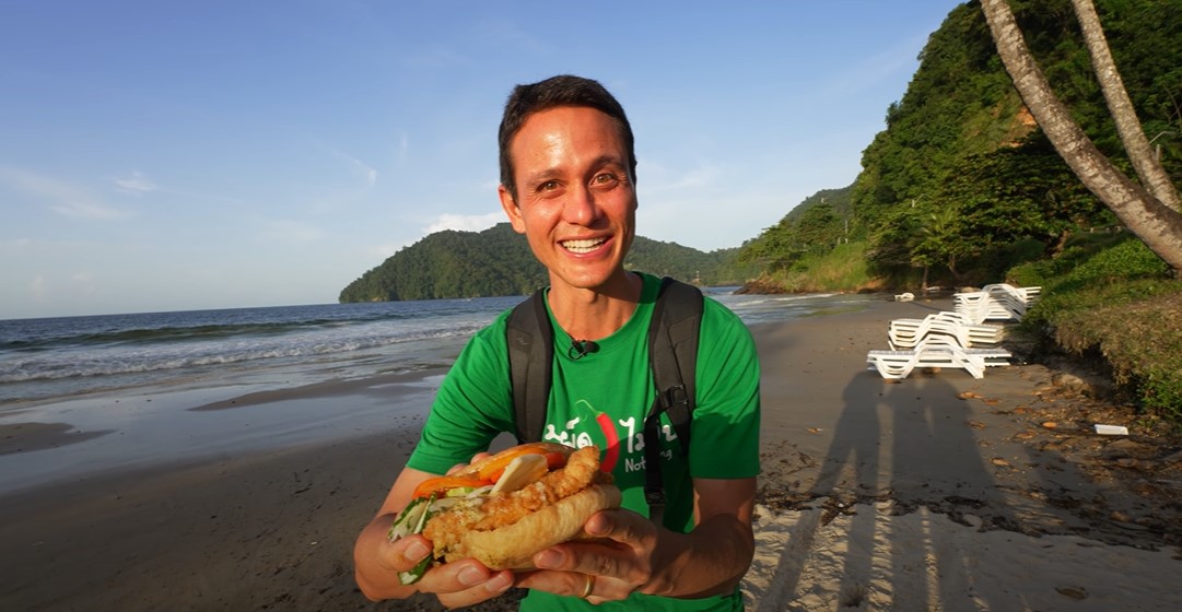 Mark Wiens at Maracas Bay eating Bake and Shark